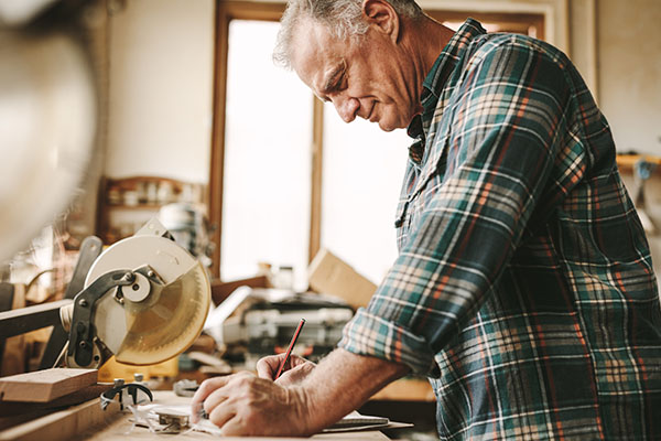 older white male working away in his garage woodshop
